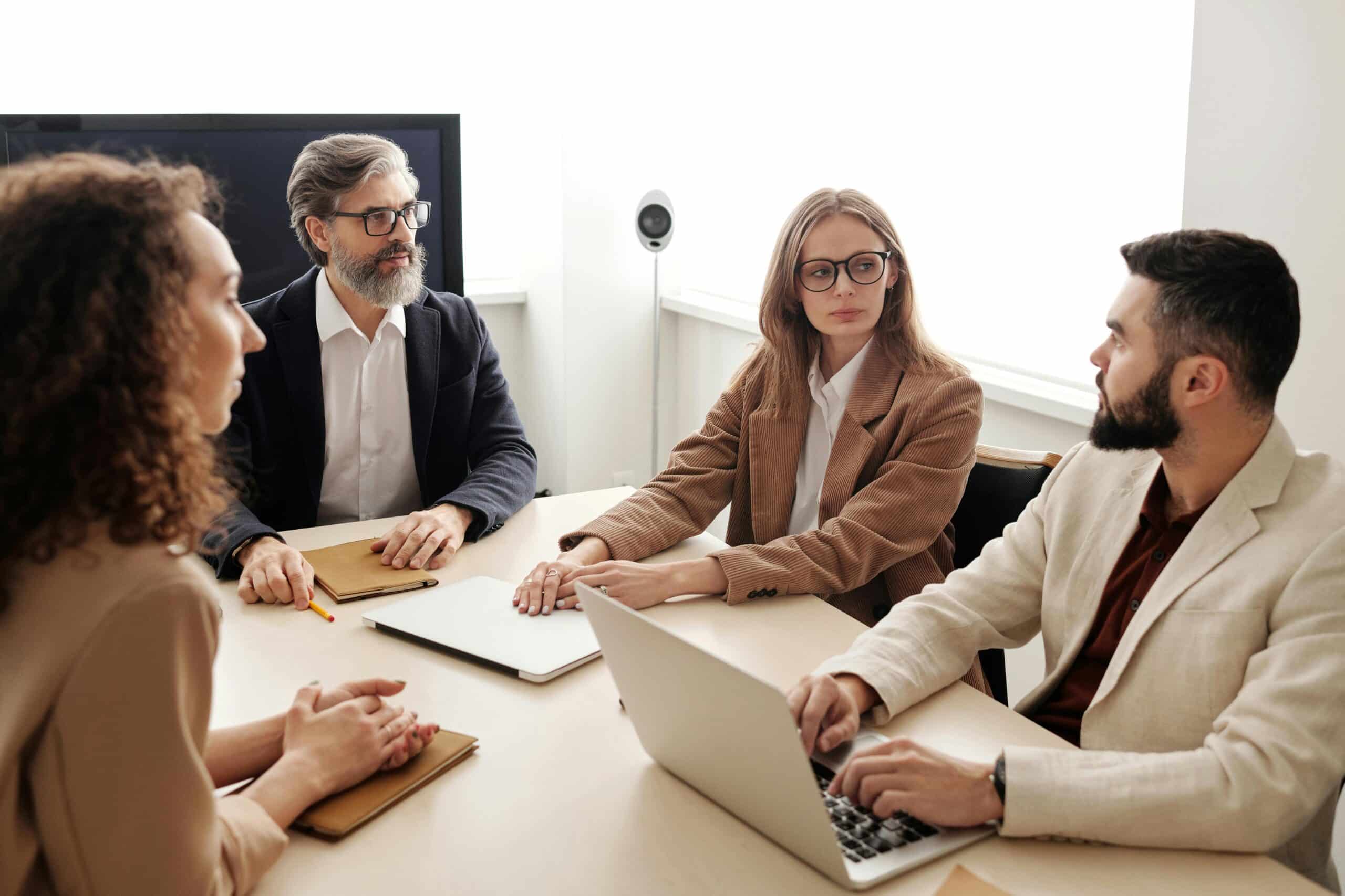 Business colleagues engaged in a serious discussion around a conference table.